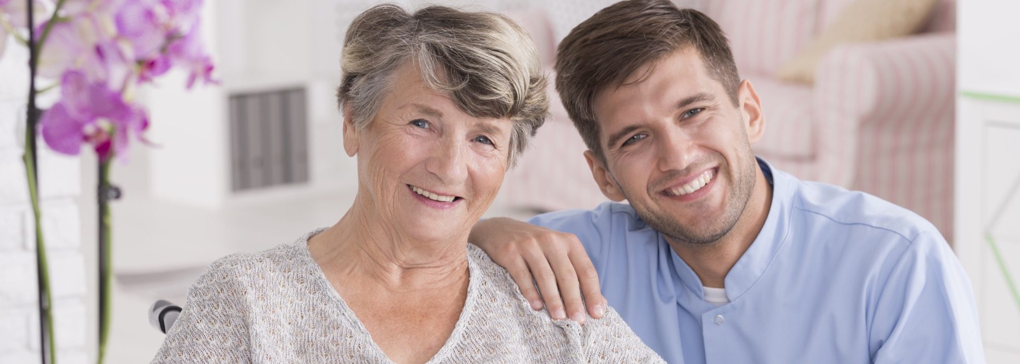 Smiling carer with senior in rest home